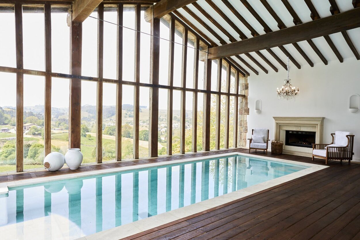 Piscina cubierta con chimenea y vistas